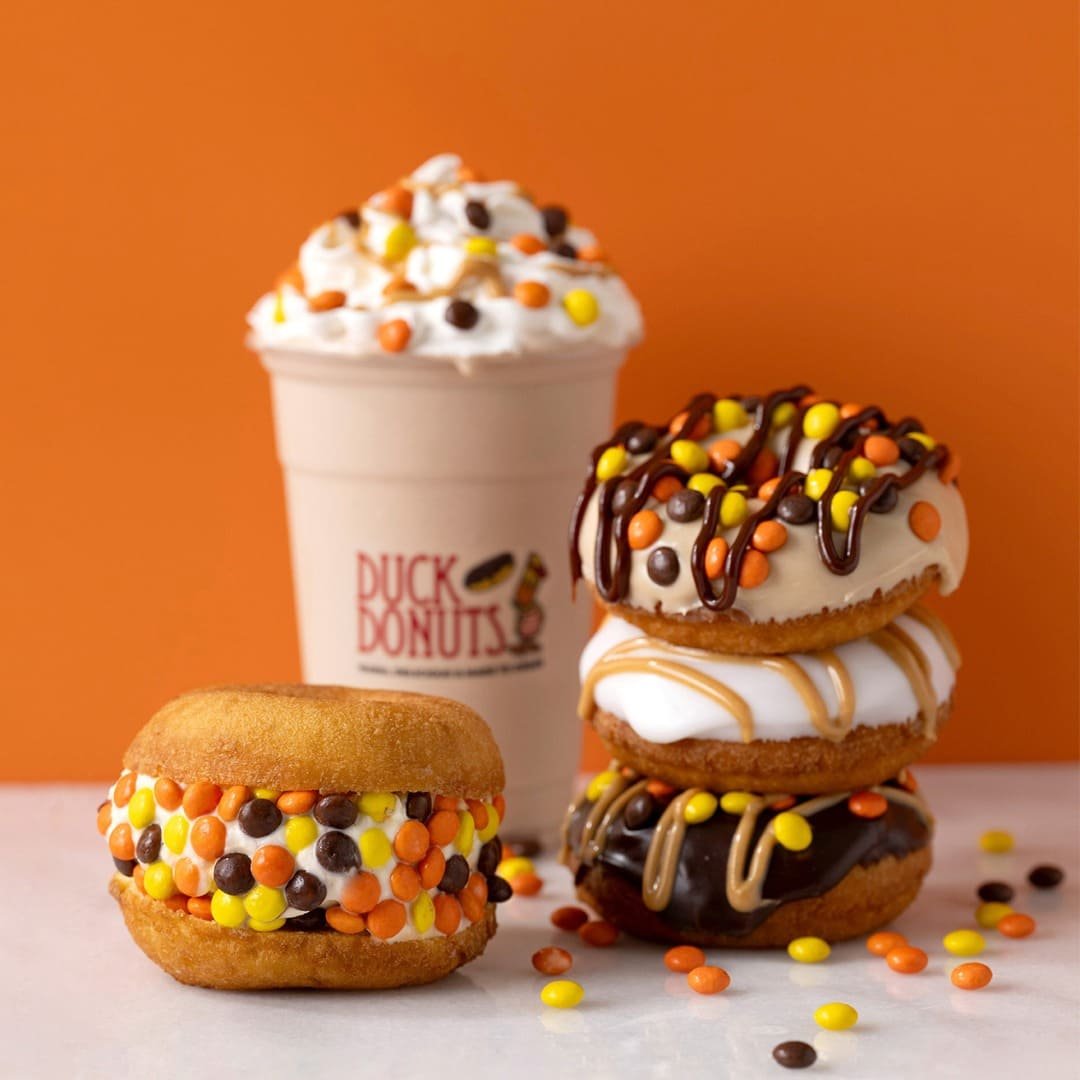 Ice cream and dessert display with colorful donuts and coffee for breakfast catering at Duck Donuts.